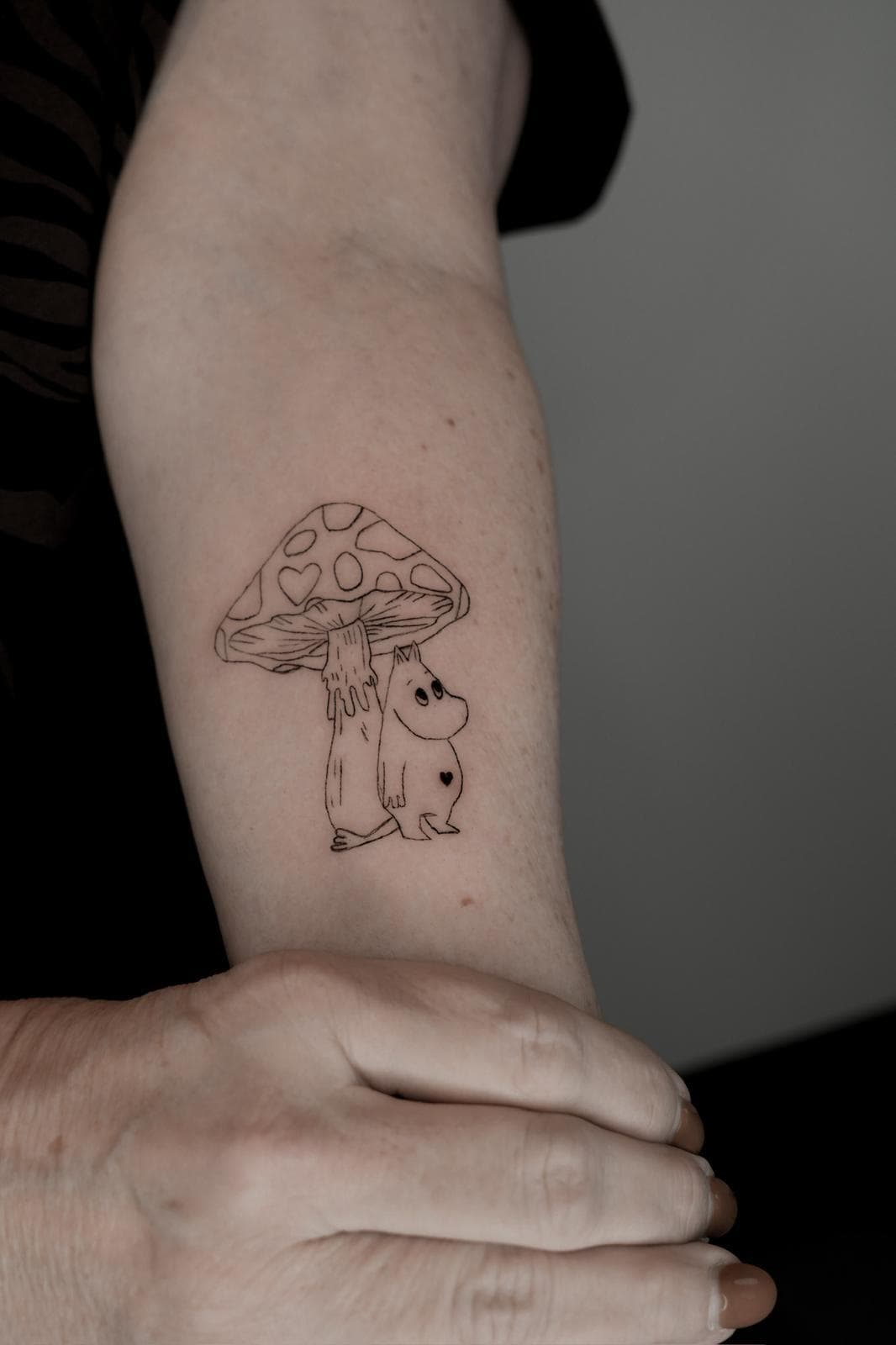 Pilz mit Mumin-Figur am Arm